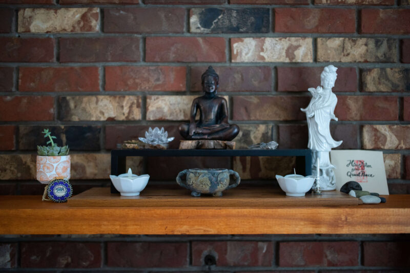 A shelf in Michele's home holding statues and pottery