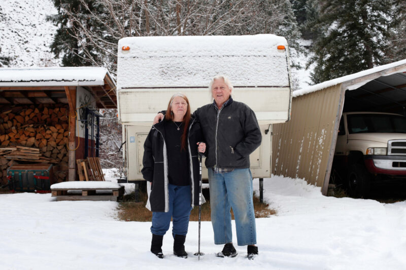 Dian and Danie standing in front of their snow covered trailer.