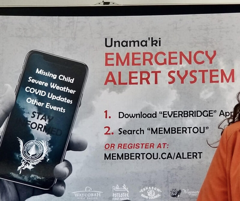 A sign showing how to download and register fo the Unama’ki Emergency Alert System